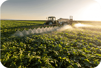 Tractor spraying fertilizers over crops enabled by ag loan